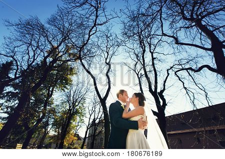 A View From Below On A Weding Couple Standing In The Autumn Park