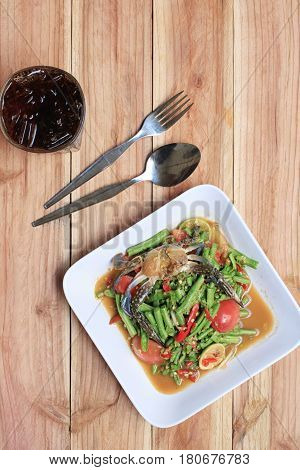 yardlong bean salad with crab of thai foods in white dish on wood background SOMTUM is food of popular in Thailand.