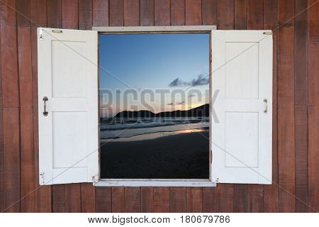 Old wooden window and have see view of sea at twilight.