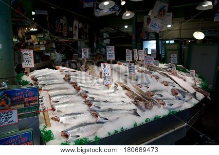 SEATTLE, WASHINGTON, USA - JAN 24th, 2017: Customers at Pike Place Fish Company wait to order fish at the famous seafood market. This market, opened in 1930, is known for their open air fish market style