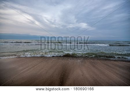 Sunset At The Sea Shore Of A Beach With Rocks And Stormy Waves, Beautiful Seascape At Caspian Sea Ab