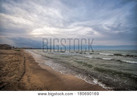 Sunset At The Sea Shore Of A Beach With Rocks And Stormy Waves, Beautiful Seascape At Caspian Sea Ab