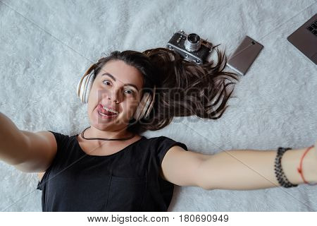 woman taking selfie in bed while listening music