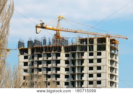 High crane on the construction of a multifamily urban residential building
