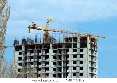 High crane on the construction of a multifamily urban residential building