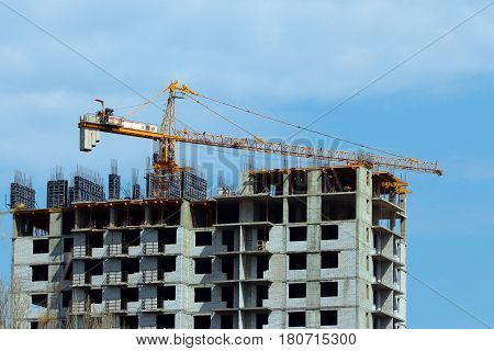 High crane on the construction of a multifamily urban residential building