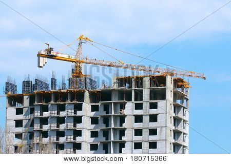 High crane on the construction of a multifamily urban residential building