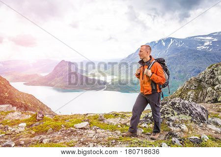 Young man hiking on Besseggen. Happy man enjoy lake and good weather in Norway
