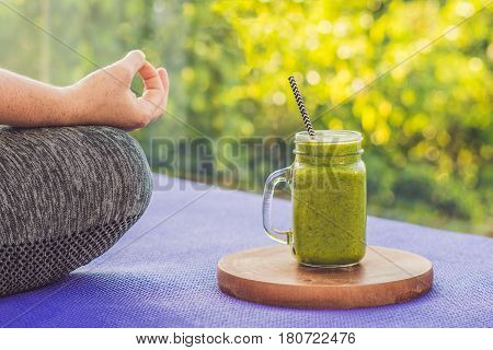 Closeup Of A Woman's Hands During Meditation With A Green Smoothies Of Spinach, Orange And Banana