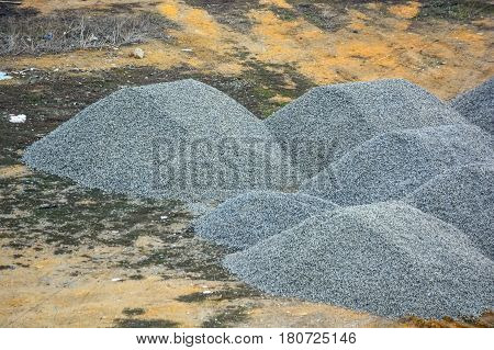 Pieces of crushed stone piled in heaps at construction site