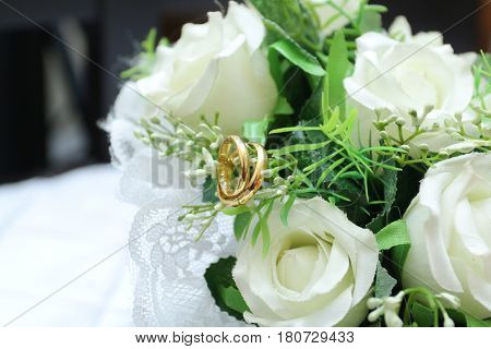 Wedding rings gold on flower bouquet close up