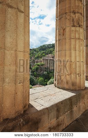 Look at largentiere through the pillars of the neoclassical courthouse in the Ardeche region of France