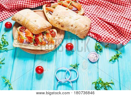 sandwich with smoked salmon on blue wooden table.