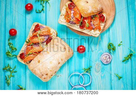 sandwich with smoked salmon on blue wooden table. Top view