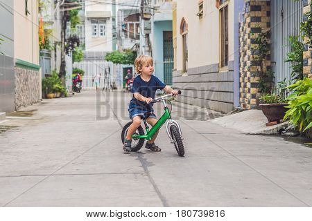 Active Blond Kid Boy Driving Bicycle N The Street Of The City. Toddler Child Dreaming And Having Fun