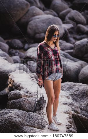 Outdoor fashion image of stylish young lady, fashionable.Lifestyle portrait of stunning hipster girl, wearing elegant glamour shirt dress and vintage sunglasses.