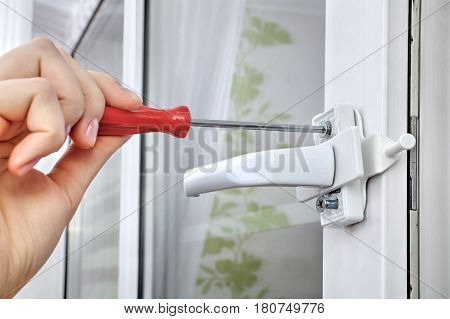 Installation of window restrictor to windows using your hands close-up.