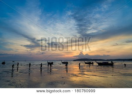 People on the Ao Nang beach at sunset in Krabi province Thailand