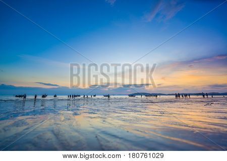 People on the Ao Nang beach at sunset in Krabi province Thailand
