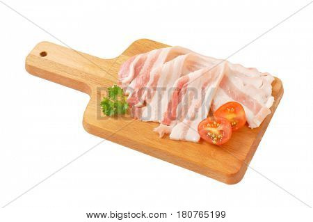 Thin slices of fresh streaky bacon on cutting board