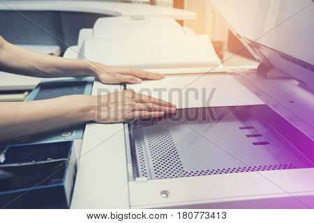 woman hand putting a sheet of paper into a copying device