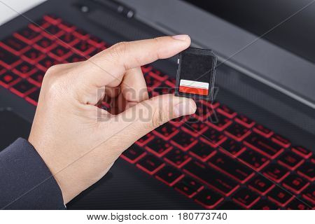 Hand Holding Sd Card With Laptop