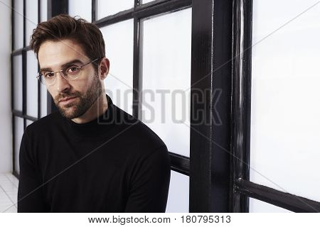 Bookish dude in black sweater and glasses portrait