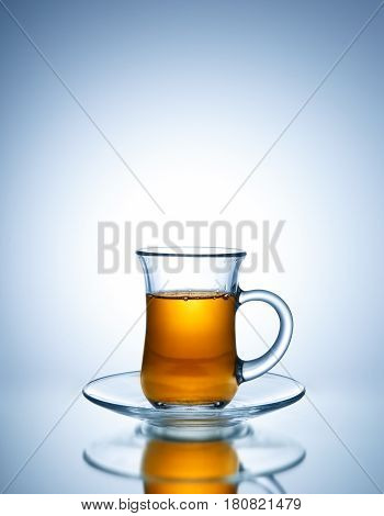 Tea in glass cup on bright background
