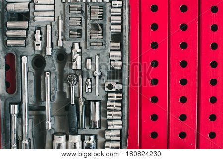 A set of accessories for the tightening of bolts lying on the background of metal constructions of red color