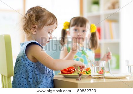 kids children eating vegetables in kindergarten daycare or at home