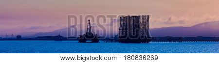 Oil platform in sea. Beautiful sunset calm sea
