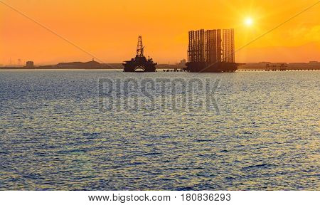 Oil platform in sea. Beautiful sunset calm sea