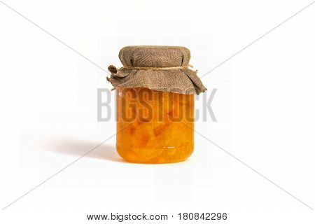 Glass jar with orange jam with slices on a white background