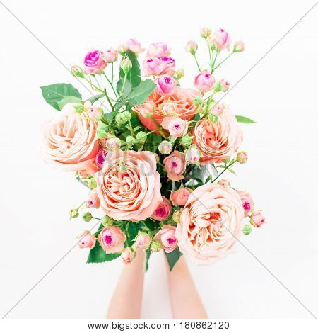 Beautiful bouquet with roses in woman hands on white background. Flat lay, top view. Holidays background