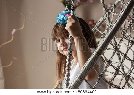 Little girl is sitting on a chair close-up
