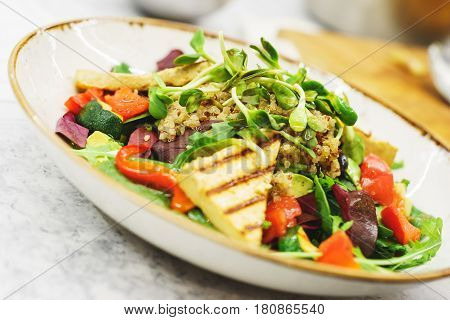 Delicious vegetarian salad with tofu and vegetables. A plate of tasty and healthy food - vitamins and health. Soft focus.