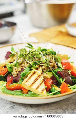 Delicious vegetarian salad with tofu and vegetables. A plate of tasty and healthy food - vitamins and health. Soft focus.