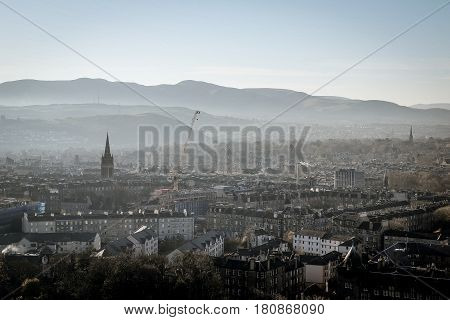 Edinburgh in the distance with hills in the background on a foggy / misty morning