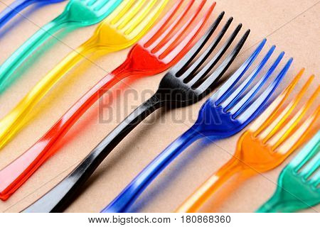 many color plastic forks on paper background