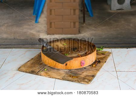 Meat cleaver on dirty cutting board. Butcher cooking knife and messy table