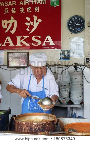 Hawker Vendor At Their Assam Laksa Noodle Stall In Air Itam, Penang