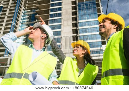 Team of architects and civil engineers inspecting construction site