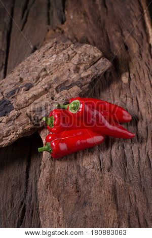 Red chilly pepper on wooden black background. Red hot chili peppers. Domestic cultivation extra hot chilli burn.
