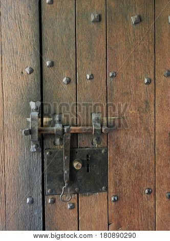 Aged wooden door with rusty iron lock