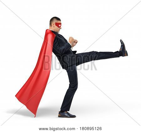 A businessman in a red superhero cape kicking an invisible object on white background. Business and competition. Adversaries. Fighting off problems.