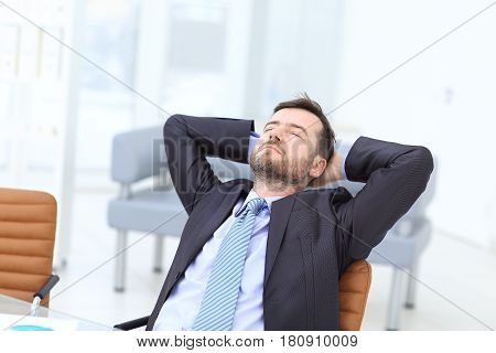 Satisfied businessman relaxing in his modern office
