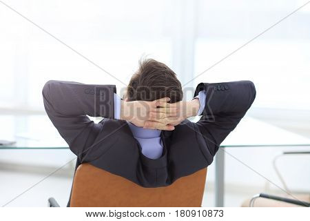 Satisfied businessman relaxing in his modern office