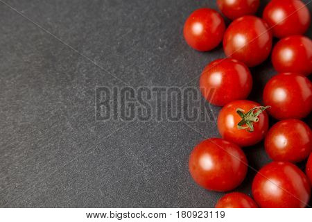 Cherry tomatoes over stone table. Top view with copy space