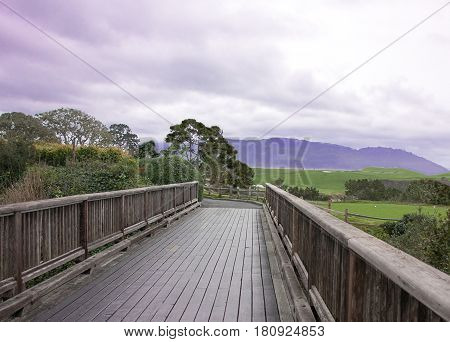 Bridge to greener pasture with purple sky