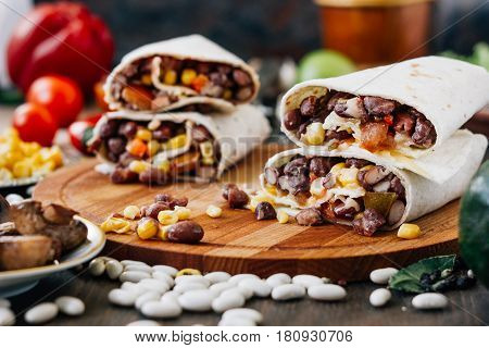 Nice Vegetarian Burrito Over Black Table On Wooden Board.